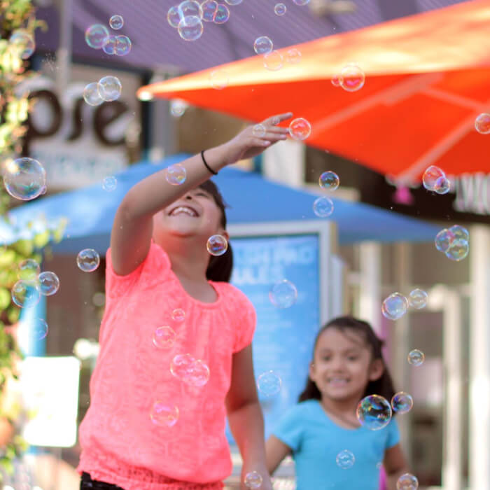 Girl smiling surrounded by bubbles.